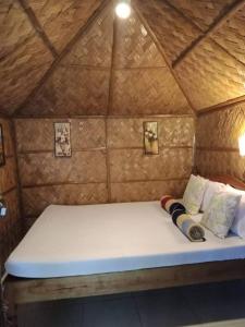 Una cama en una yurta con almohadas. en Al Hamra Jungle Resort, en Puerto Princesa City