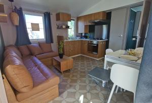 a living room with a couch and a table and a kitchen at Les sables du Midi 4 in Sérignan