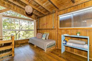 ein Schlafzimmer mit einem Bett in einer Holzhütte in der Unterkunft Moradas do Vale Praia do Rosa in Praia do Rosa