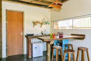 eine Küche mit einer Theke und Hockern in einem Zimmer in der Unterkunft Moradas do Vale Praia do Rosa in Praia do Rosa