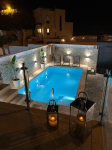 Luxury house Atlantico private heated pool في أديخي: مسبح أزرق كبير في الليل مع أضواء