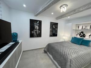 a bedroom with a bed and some pictures on the wall at Luxury house Atlantico private heated pool in Adeje