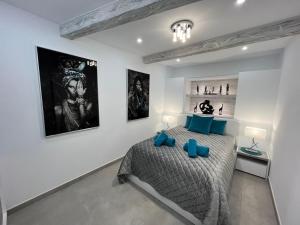 Luxury house Atlantico private heated pool في أديخي: غرفة نوم بسرير وبعض الصور على الحائط