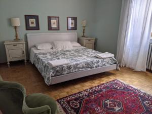 a bedroom with a bed and two chairs and a rug at Agriturismo Azienda Agricola Mombisaggio in Tortona