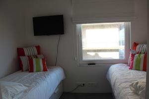 デ・パンネにあるDuplex Penthouse Plazaの小さなベッドルーム(ベッド2台、窓付)