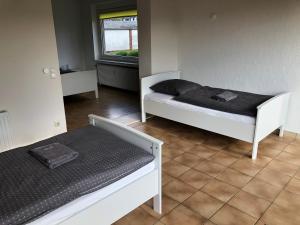 een kamer met twee bedden en een raam bij Gästehaus Stadthagen in Stadthagen +10 foto's