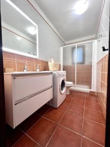 een badkamer met een wasmachine en een wastafel bij La casa de Tenesedra in Mocanal