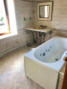 y baño con bañera y lavamanos. en Maison chaleureuse au cœur du village Raddon, en Raddon-et-Chapendu