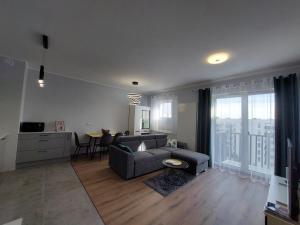 een woonkamer met een bank en een tafel bij Kamienica Nova VITORE 116 in Szczecin