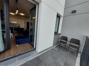 een balkon met 2 stoelen en een woonkamer bij Kamienica Nova VITORE 116 in Szczecin