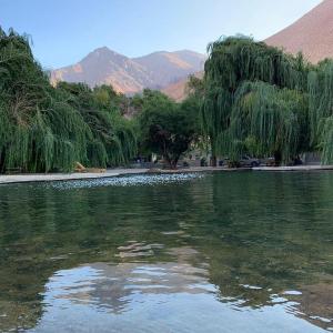 ein Wasserkörper mit Bäumen und Bergen im Hintergrund in der Unterkunft Glamping Miraflores in Vicuña