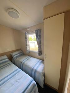 two beds in a small room with a window at 14 Greenwood Thorness Bay in Porchfield