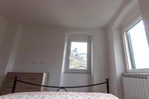 1 dormitorio con cama y ventana en Near - Cinque Terre Holiday Apartment, en Riccò del Golfo di Spezia