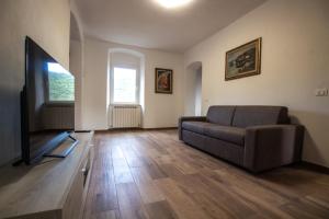 sala de estar con sofá y TV de pantalla plana en Near - Cinque Terre Holiday Apartment, en Riccò del Golfo di Spezia