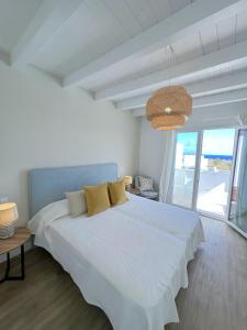 um quarto branco com uma grande cama branca com almofadas amarelas em Casahost Villa Dolce Vita em Costa Teguise