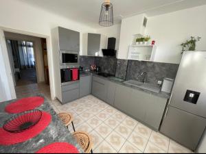 uma cozinha com uma bancada e um frigorífico em Très grand appartement à 10 min à pied du centre em Castres