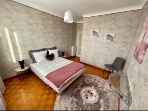 - une chambre avec un lit et une chaise dans l'établissement Très grand appartement à 10 min à pied du centre, à Castres