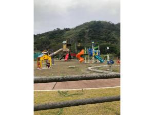 un parco giochi in un parco con una collina sullo sfondo di Fukugi no Yado - Vacation STAY 94994v ad Amami