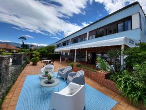 an outdoor patio with white chairs and tables at Hotel Bahia in La Isla