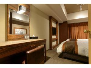 a bedroom with a bed and a dresser with a mirror at HOTEL RELIEF Namba Daikokuchou - Vacation STAY 33958v in Osaka