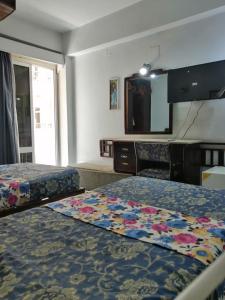 Habitación de hotel con 2 camas y TV de pantalla plana. en Windsor Hotel Luxor en Luxor