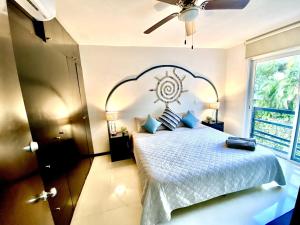 een slaapkamer met een bed en een plafondventilator bij VIA TENDENZA VILLAS in Playa del Carmen +20 foto's