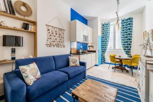 salon z niebieską kanapą i kuchnią w obiekcie Studio Shell 26M2, 120m Vieux-Port, Clim, Wifi, Accès autonome avec code w Marsylii