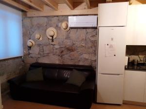 - un salon avec un canapé noir à côté d'un mur en pierre dans l'établissement Casa da Florbela, à Fafe