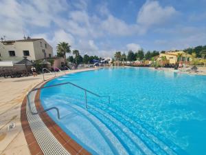 a large swimming pool with blue water at Les sables du Midi 4 in Sérignan