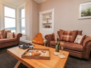 a living room with couches and a wooden table at Argyle House in Rothesay