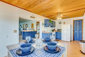 a kitchen with blue cabinets and a table with wine glasses at Sunshine Escape in Vero Beach