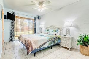 - une chambre avec un lit et un ventilateur de plafond dans l'établissement Sunshine Escape, à Vero Beach