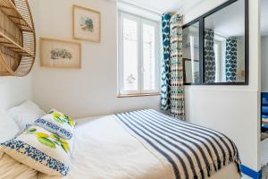 Habitación pequeña con cama y ventanas en Le Grand Studio Bleu 29M2, 120m Vieux-Port , Clim ,Wifi, Accès autonome avec code, en Marsella 6 fotos más