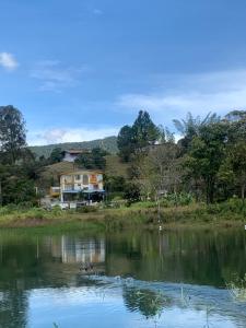 a house on a hill next to a lake at Alegria Hostel Boutique in Guatapé