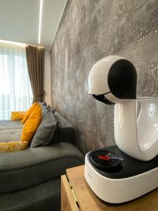 Un robot blanc assis sur une table à côté d'un lit dans l'établissement Modern 1Bed Apartment for 4 guests in Sofia, à Sofia