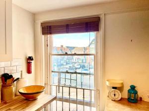 a kitchen with a window with a view of a harbor at Charming 2 bed flat market square in Oxfordshire in Grove