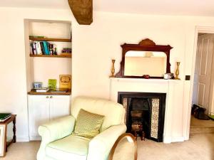 a living room with a chair and a fireplace at Charming 2 bed flat market square in Oxfordshire in Grove