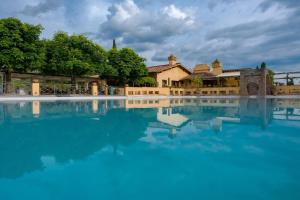 uma piscina de água em frente a um edifício em FIRENZE Villa a 5 Stelle - Villa Gaudia Luxury & Relax in Chianti em Florença