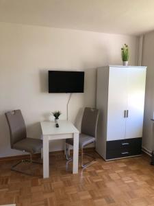 a room with a table and two chairs and a white cabinet at Gästehaus Stadthagen in Stadthagen