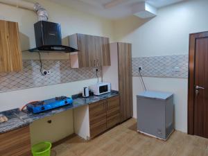 a kitchen with a counter with a microwave and a refrigerator at Abuja Apartments 24 in Abuja