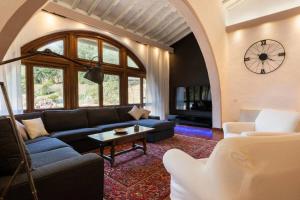 un soggiorno con divano blu e orologio di FIRENZE Villa a 5 Stelle - Villa Gaudia Luxury & Relax in Chianti a Firenze