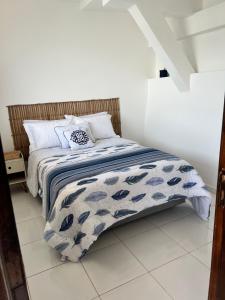 a bed with a blue and white comforter in a room at Casa Marambaia 2 in Rio de Janeiro