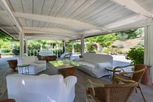 un patio con mobili bianchi e soffitto in legno di FIRENZE Villa a 5 Stelle - Villa Gaudia Luxury & Relax in Chianti a Firenze