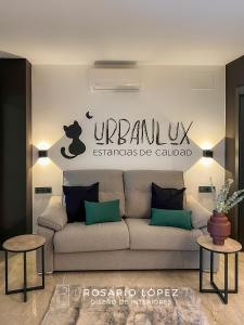una sala de estar con sofá y un cartel en la pared en Urbanlux Olimpia Pet Friendly, en Albacete