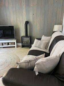 a living room with a couch and a television at Shakespeare’s Nest in Prescot