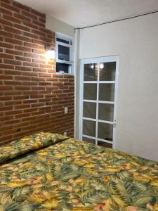 a bedroom with a bed and a brick wall at Hotel Villas La Mexicana in Tecozautla