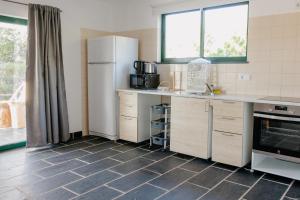 uma cozinha com um frigorífico e piso em azulejo em Monte Carvalhal da Rocha na Zambujeira do Mar