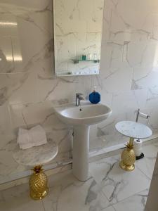 Baño blanco con lavabo y espejo en Brooke Lodge Guesthouse en Magherafelt