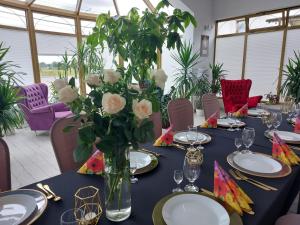 une table avec un vase de fleurs sur elle dans l'établissement Hotel u Liska, à Kutno