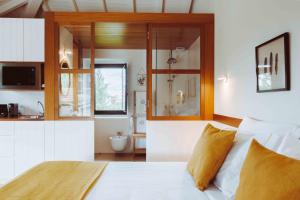 a bedroom with a white bed and a bathroom at Oliveiras Village — Agroturismo in Amarante